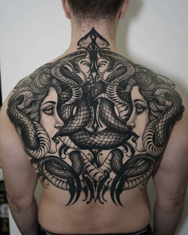 7sinstattoo.live Osoba z misternym, czarno-szarym tatuażem pokrywającym całe plecy, znana jako DSC03455, przedstawia dwie kobiety zwrócone ku sobie, otoczone splecionymi wężami, tworząc symetryczny i wyszukany wzór. To arcydzieło zostało wykonane przez artystę ze studia tatuażu Poznań. Najlepsze studio tatuażu Seven Sins Tattoo
