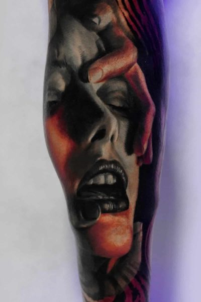 Produkt „431203306_18258281038232848_8513464638289209236_n” z 7sinstattoo.live prezentuje misterny, szczegółowy tatuaż na dłoni, żywo przedstawiający twarz wykrzywioną kontrolęm. Dramatyczny projekt przedstawia dłoń trzymającą czubek głowy, z otwartymi ustami i zamkniętymi drzwiami, odbierającymi sygnały one przez oświetlenie i cienie w studiu Seven Sins Tattoo w Poznaniu.