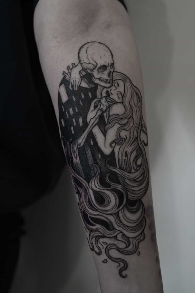 7sinstattoo.live Tatuaż na przedramieniu zaprojektowany w studio tatuażu Poznań, oznaczony jako DSC06789, przedstawia szkielet obejmujący kobietę o długich, rozpuszczonych włosach. Szczegółowo wykonany czarnym tuszem, kostna postać szkieletu kontrastuje z płynnymi liniami jej włosów, tworząc eteryczny i niepokojący efekt. Najlepsze studio tatuażu Seven Sins Tattoo