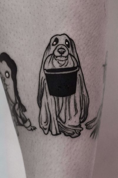 7sinstattoo.live Czarno-biały tatuaż, oznaczony jako DSC09964, przedstawia kreskówkową kreaturę z opadającymi oczami i długimi włosami pokrywającymi ciało, trzymającą wiadro. Wzór jest wytatuowany na bladej skórze w tatuaż Poznań. Inne częściowe wzory tatuaży są widoczne w pobliżu. Najlepsze studio tatuażu Seven Sins Tattoo