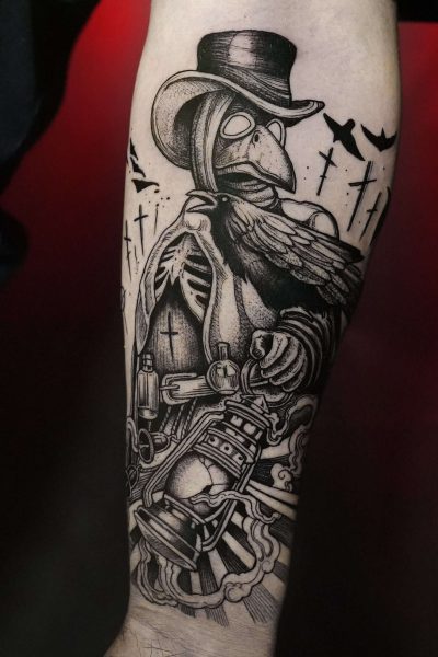 7sinstattoo.live Szczegółowy czarno-szary tatuaż na ramieniu ze studia tatuaży Poznań przedstawia F072EF6C-A0D7-44B2-B2F4-9E9E6A720D31, przedstawiający lekarza dżumy o szkieletowych rysach twarzy trzymającego latarnię. Postać nosi długi płaszcz, kapelusz i maskę przypominającą dziób. Krzyże i latające wrony w tle dodają mrocznej i niesamowitej atmosfery.

 Najlepsze studio tatuażu Seven Sins Tattoo